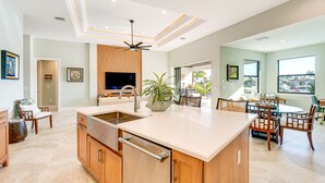 Una cucina moderna con un'isola grande, mobili in legno e lavastoviglie integrata.