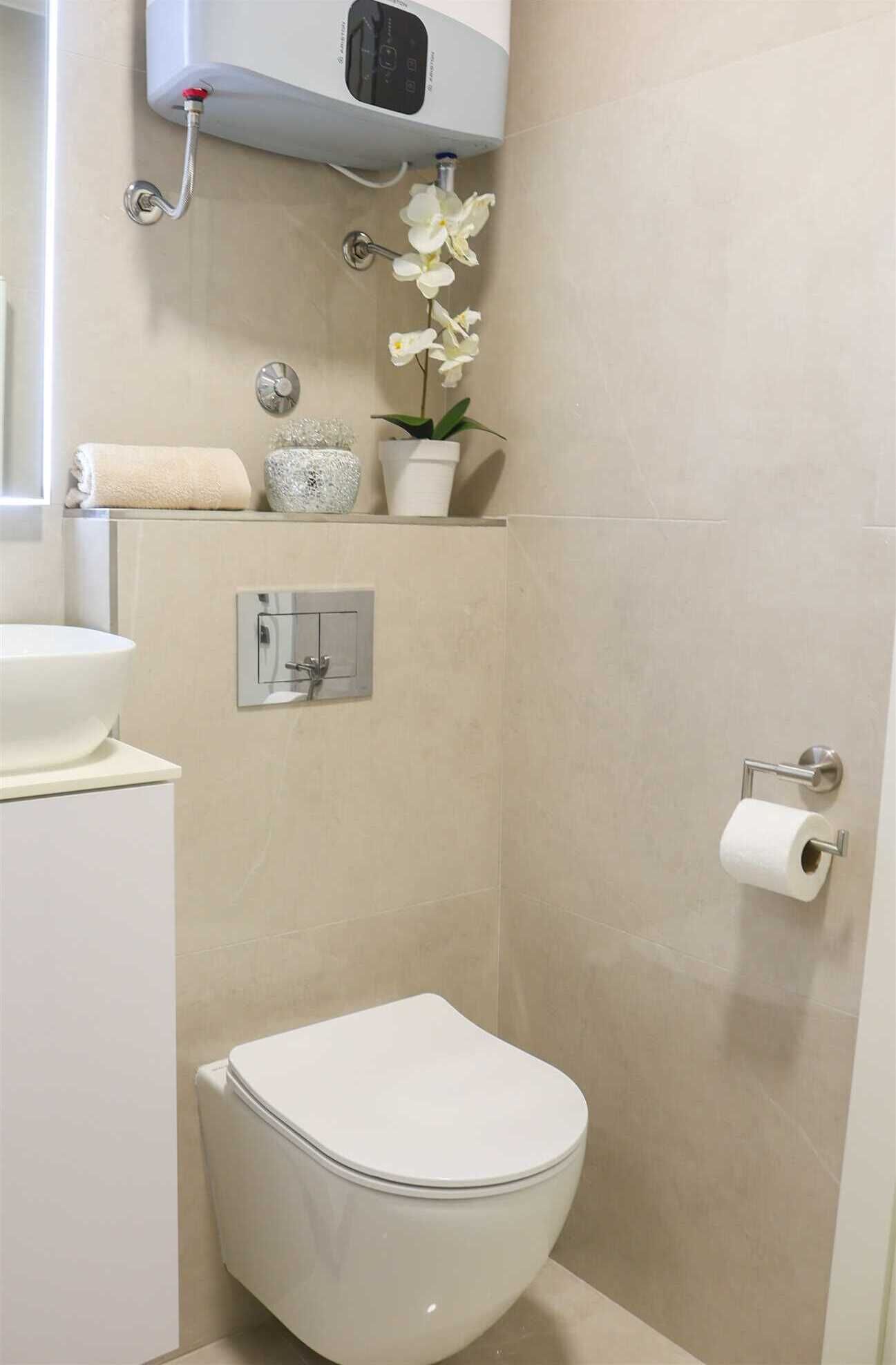 A modern bathroom with a toilet, sink, and shower.