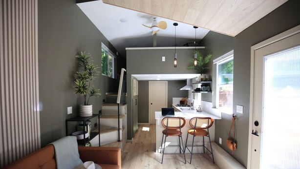 A modern kitchen with a dining area, wooden flooring, and a ceiling fan. - Blue Lakes Village (Upper Lake)