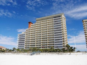 A multi-story hotel with a uniform exterior, located near a beach.