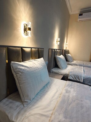 Chambre triple Standard, vue sur la ville | Aire de séjour | Téléviseur de 43 po avec télévision par satellite