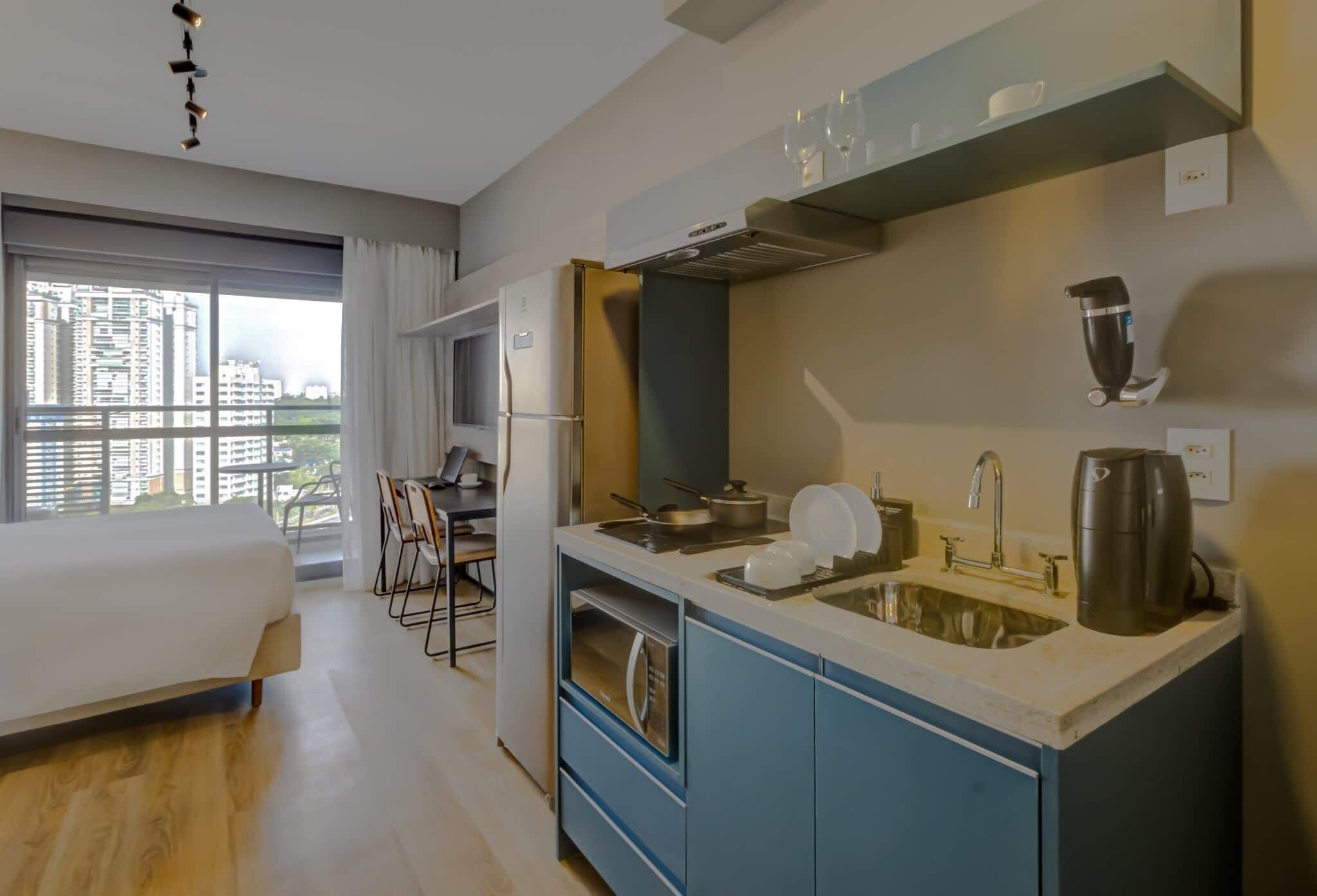 A modern kitchen with a built-in oven, a sink, and a coffee maker.