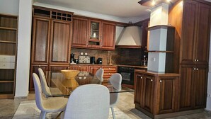 Eine moderne Küche mit Holzausstattung, einem Glastisch und einem Einbauofen.