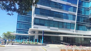 A modern building with multiple glass windows and a flat roof. - Luxury 1BR 55sqm 1 Pacific MactanNewtown (Lapu-Lapu)