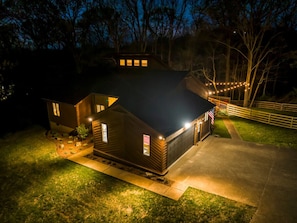 A two-story house with a dark roof, a front porch, and a small deck.