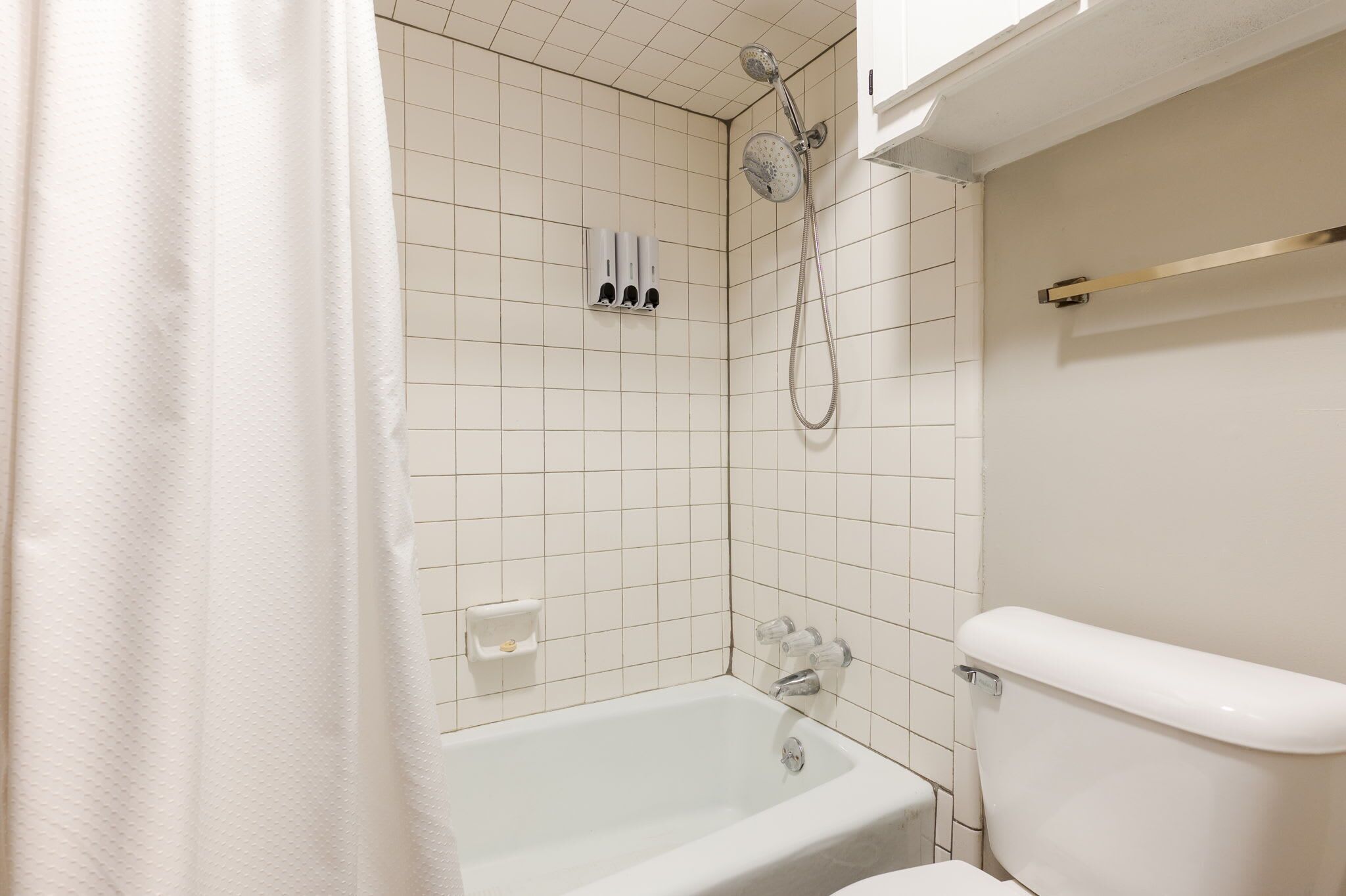 Un baño con bañera, inodoro y ducha.