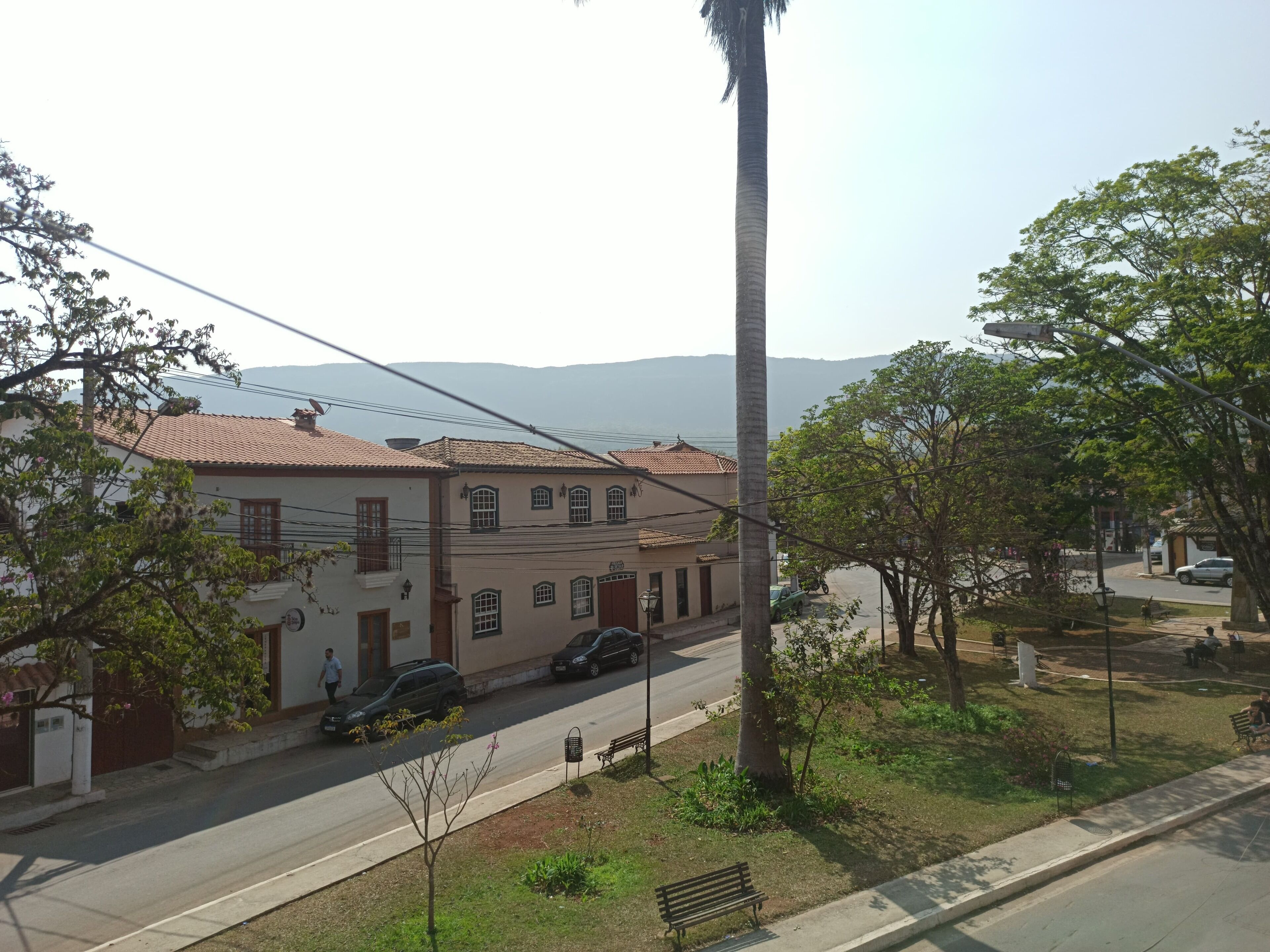 A residential street with houses, a palm tree, and a clear view of distant mountains.