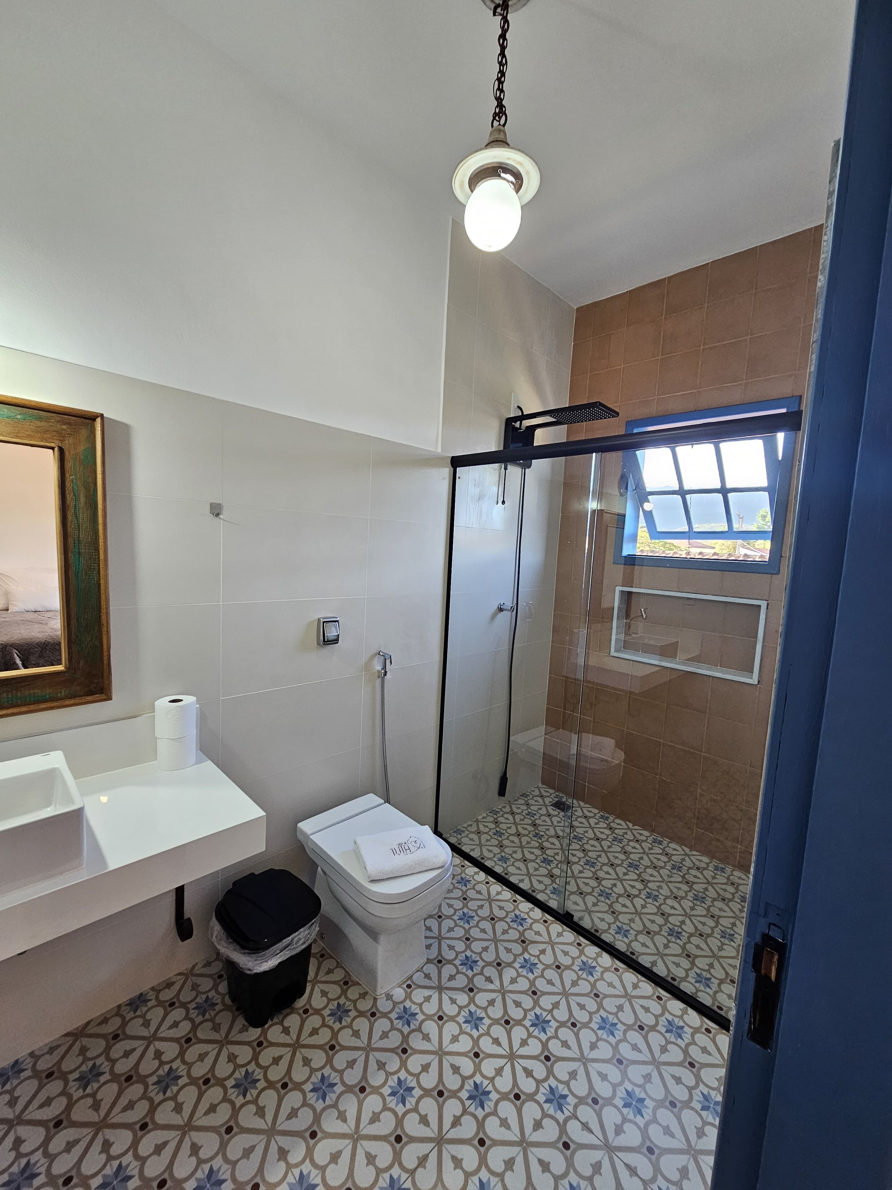 Un baño con inodoro, lavamanos y zona de ducha.