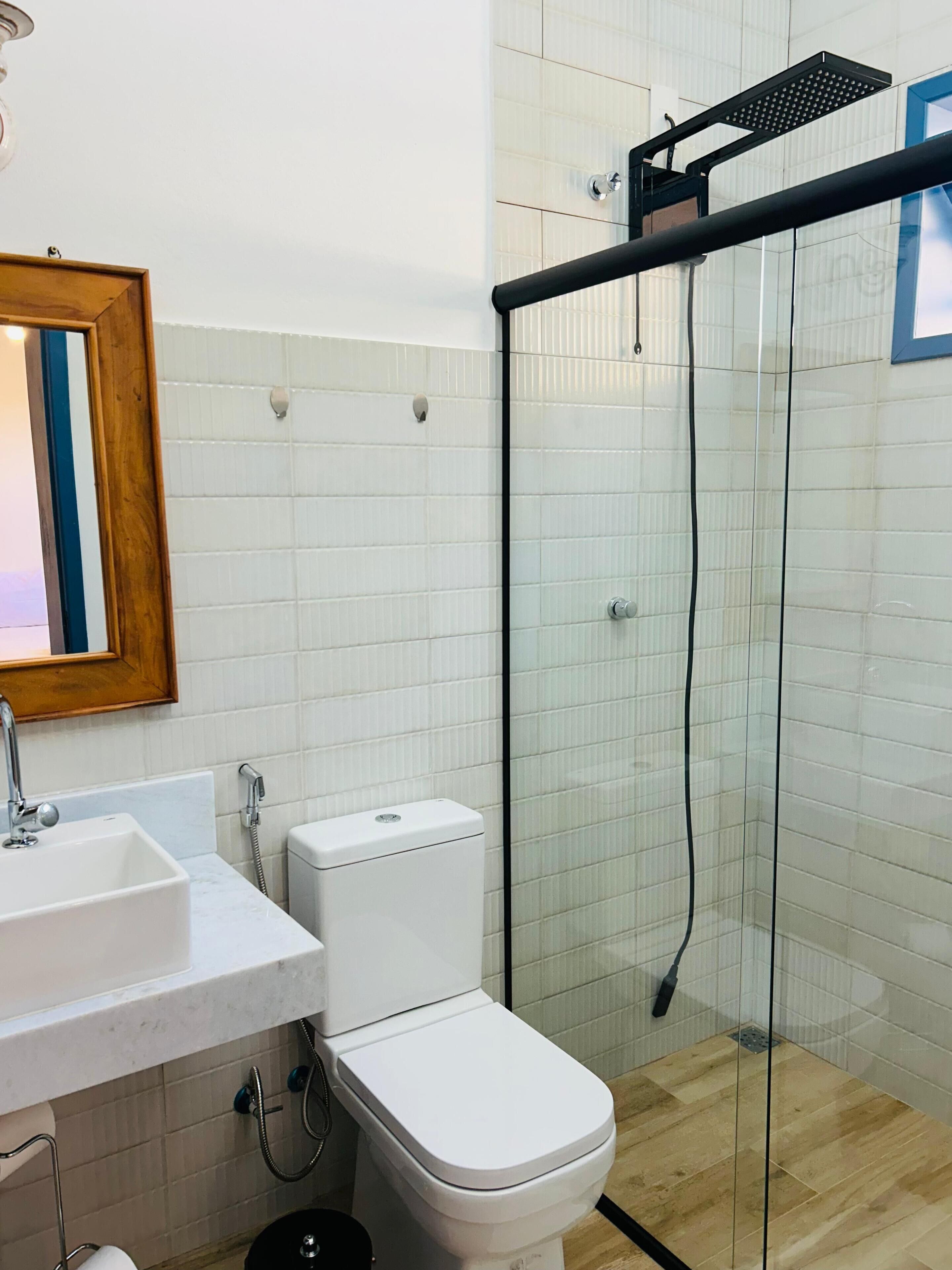 A bathroom with a toilet, sink, and glass-enclosed shower.