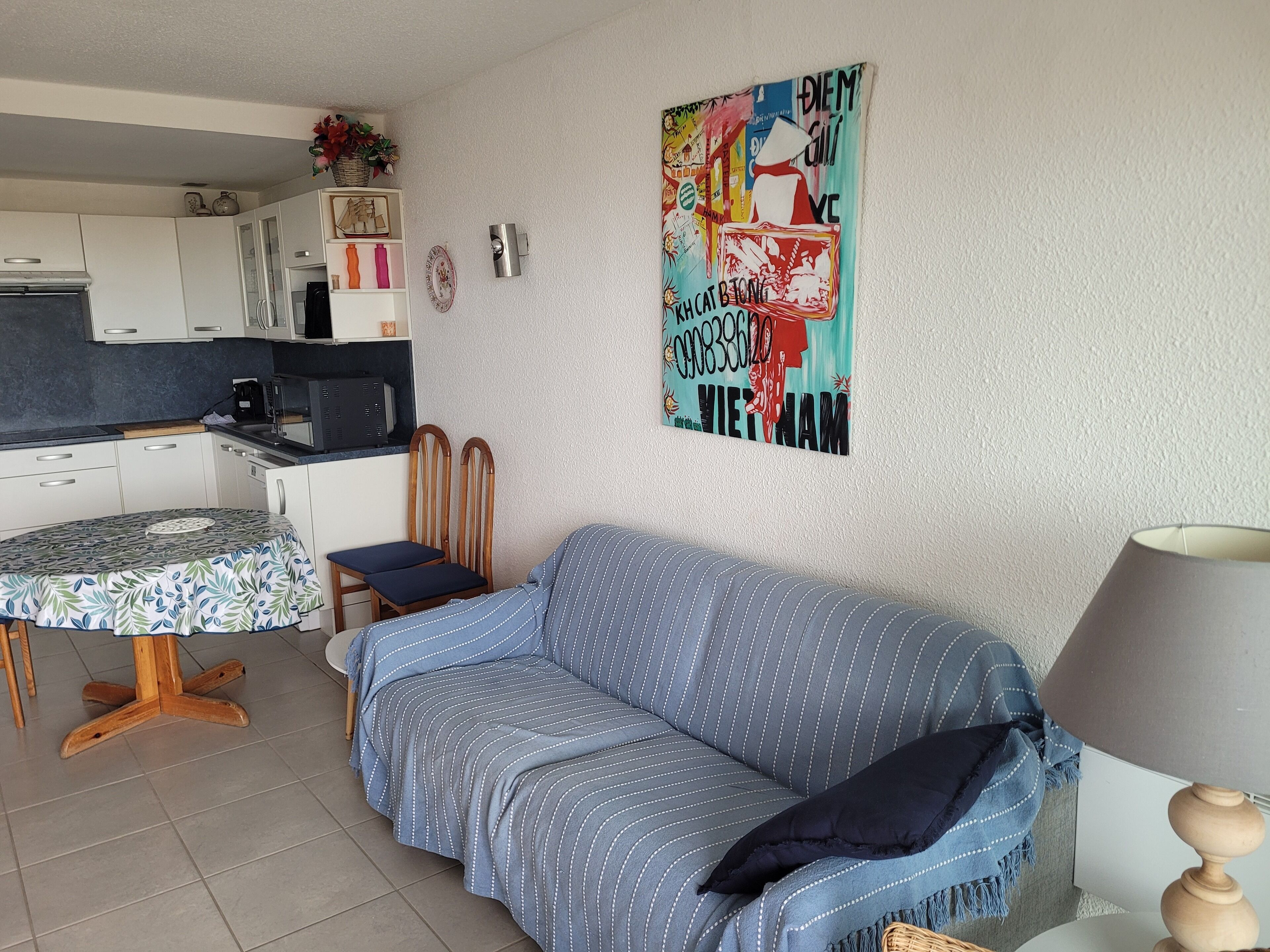 Un espacio habitable compacto con kitchenette, una mesa de comedor y un sofá.