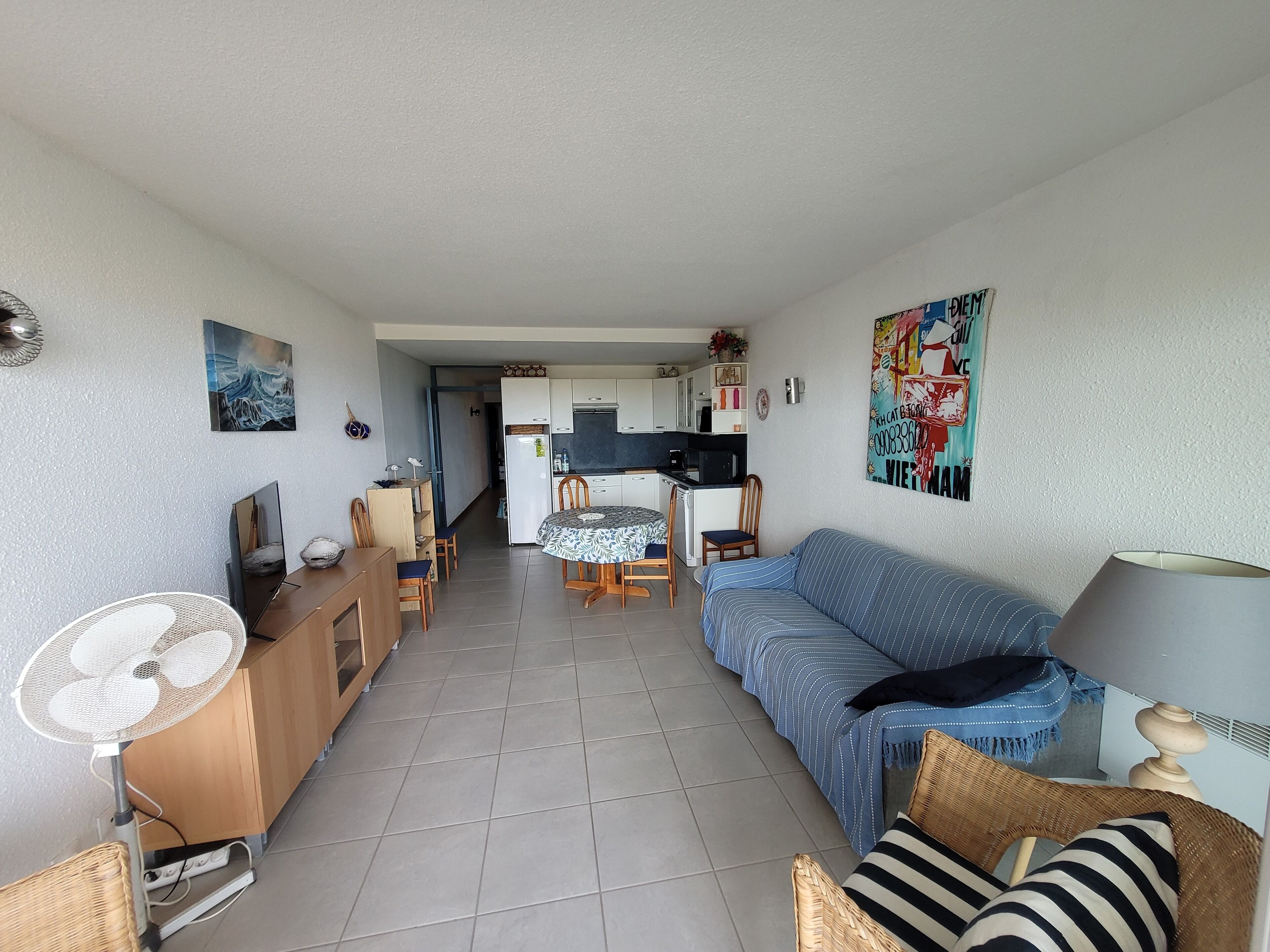 A compact living space with a kitchenette, dining area, and a sofa.