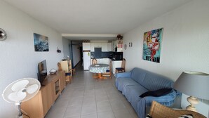 A compact living space with a kitchenette, dining area, and a sofa. - Appartement Avec vue Mer à Marseillan Plage (Marseillan)