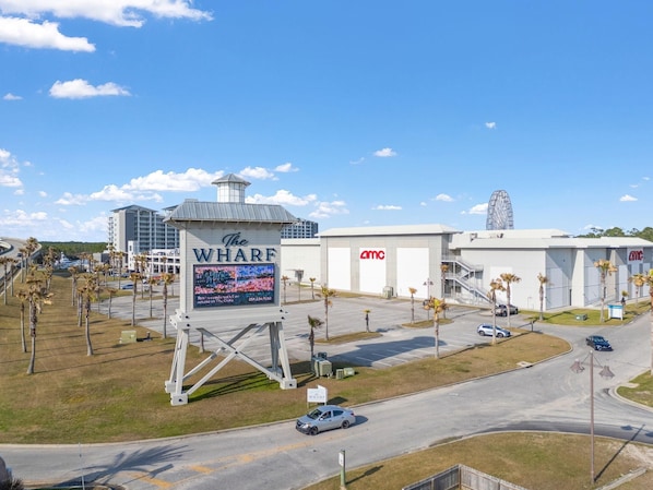 A hotel with a large sign, a parking lot, and a Ferris wheel in the background.