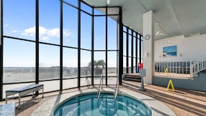 A pool area with a view of the city, a bench, and a staircase.