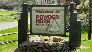Willkommensschild für den Powder Horn Mountain mit einem Pfeil, der nach Chapel zeigt.