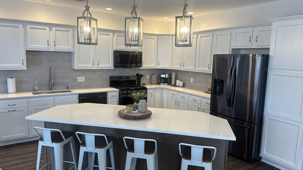 A modern kitchen with white cabinets, stainless steel appliances, and pendant lighting. - NEWLY BUILT condo - premium features, game room, firepit, short walk to village (Ellicottville)