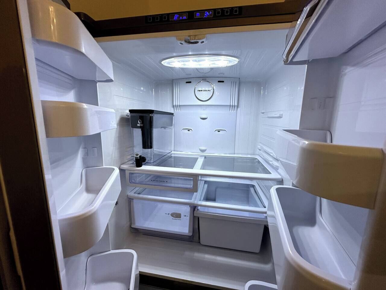 A compact kitchen with a refrigerator, sink, and a microwave.