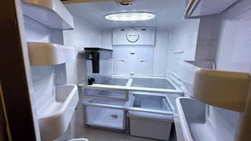 A compact kitchen with a refrigerator, sink, and a microwave.