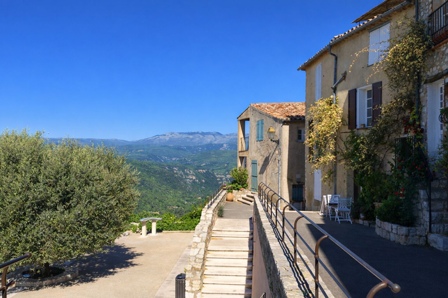 A stone staircase leading to a building with a view of mountains.