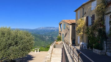 A stone staircase leading to a building with a view of mountains.