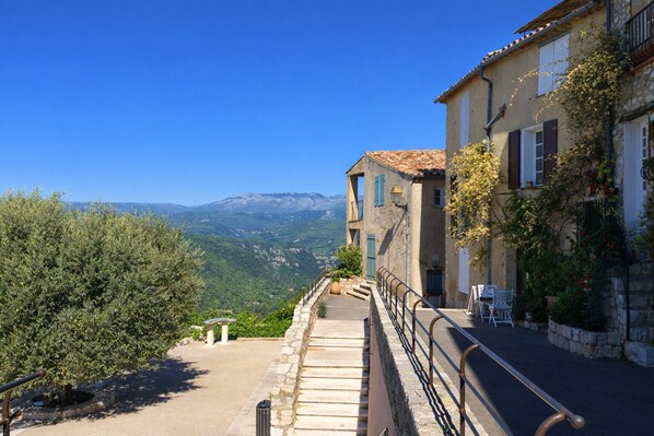 A stone staircase leading to a building with a view of mountains.