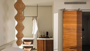 Un baño moderno con un tocador de madera, una lámpara colgante y una puerta corredera.