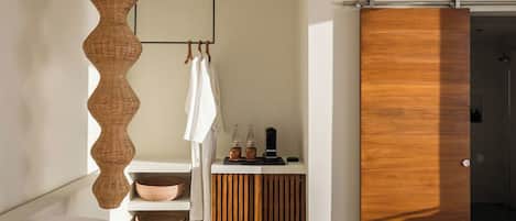 Un baño moderno con un tocador de madera, una lámpara colgante y una puerta corredera.