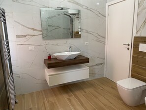 Een douche, een haardroger, een bidet, handdoeken