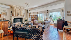 Amplia sala de estar con chimenea, un conjunto de sofás y un comedor.