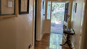 A hallway with wooden flooring, framed certificates on the walls, and a chandelier. - Ruston House - Port of Echuca (Echuca)