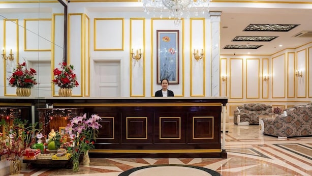 Un área de recepción con una araña, una recepcionista y un sofá.