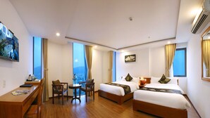 A hotel room with two beds, a desk, and a chair. - Merry Land Hotel Da Nang (Da Nang Municipality)