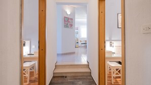 A hallway with wooden doors leading to a dining area with a table and chairs. - Nice home in Pozla Gora (Pozla Gora)