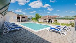 A pool area with lounge chairs, a covered seating area, and a view of the surrounding landscape. - Nice home in Pozla Gora (Pozla Gora)