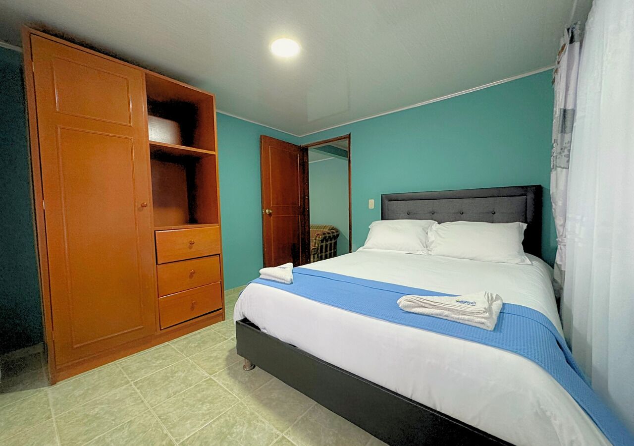 Quarto com cama, guarda-roupa e espelho.