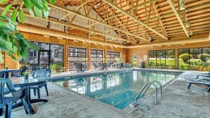 An indoor swimming pool with a wooden ceiling and surrounding seating. - First Floor Pet Friendly Queen Suite with Single Pull-out (Elkhart Lake)