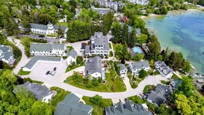 An aerial view of a residential area with houses, a large building with a tower, and a body of water. - First Floor Pet Friendly Queen Suite with Single Pull-out (Elkhart Lake)