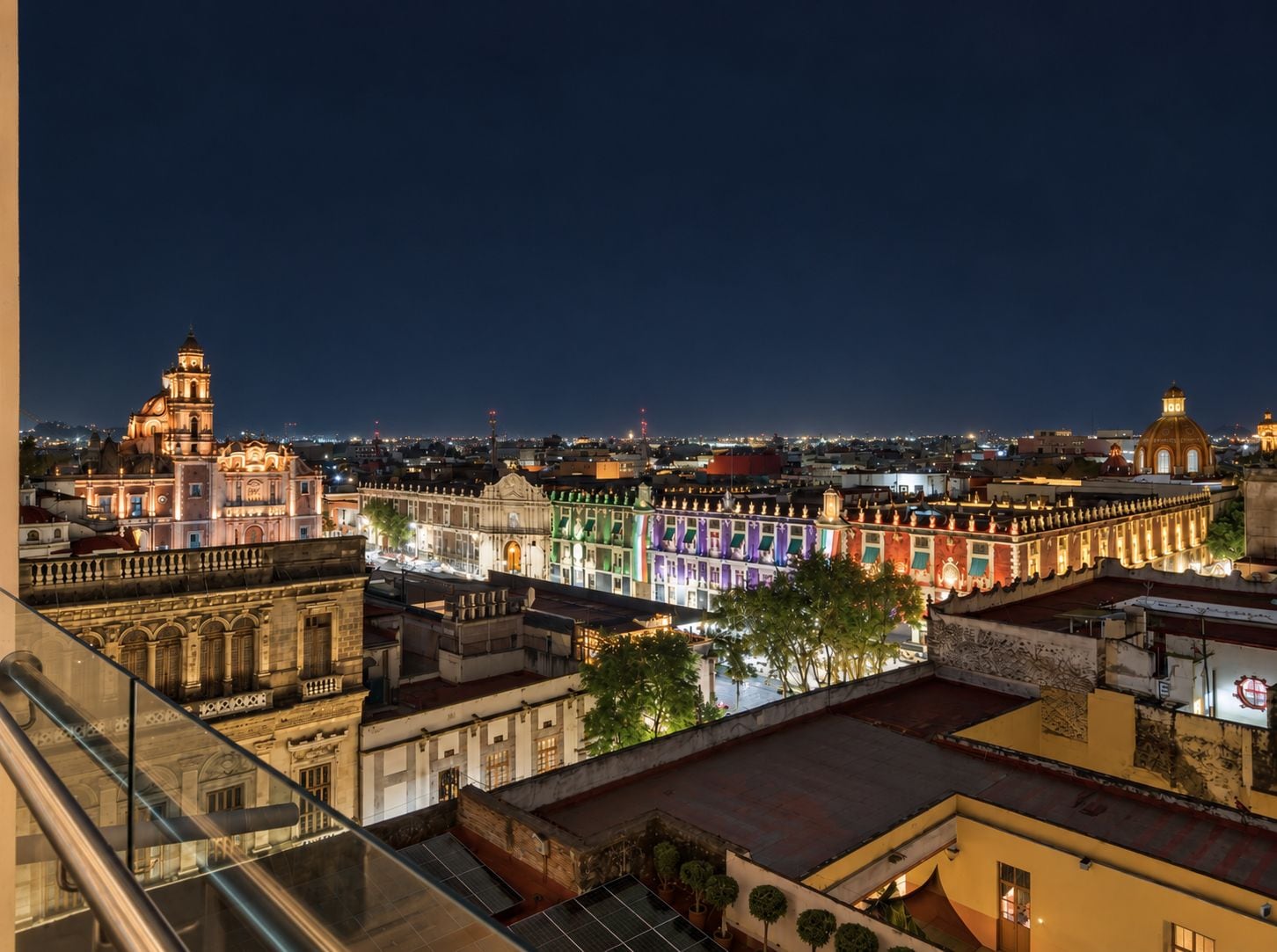 A nighttime cityscape with illuminated buildings and a clear view of the urban landscape.