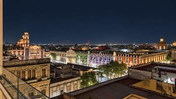 A nighttime cityscape with illuminated buildings and a clear view of the urban landscape.