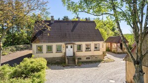 Ein eingeschossiges Haus mit Satteldach, einer Haustür und einer kleinen Veranda.