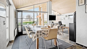 A modern kitchen with a large dining table, chairs, and a TV. - 4 bedroom lovely home in Faaborg (Faaborg)