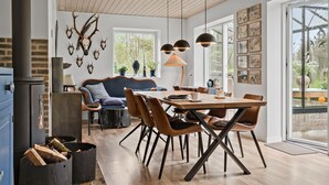 Een moderne eetruimte met een houten tafel en stoelen, een bank en een open haard.