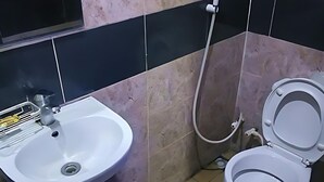Une salle de bain avec un lavabo, des toilettes et une douche, le tout de couleur blanche.