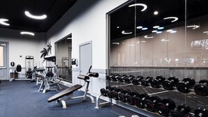 A gym with weightlifting equipment, dumbbells, and cardio machines. - Salted Tranquility at The Palms Of Destin (Destin)
