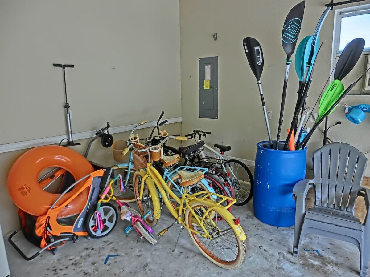 A garage with bicycles, a scooter, and a kayak rack.