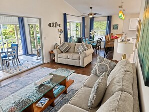 Ein Wohnzimmer mit einer Couch, einem Couchtisch und einem Essbereich mit Stühlen und einem Tisch.