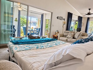 Ein Schlafzimmer mit einem großen Bett, einer Couch und einem Essbereich mit Stühlen.