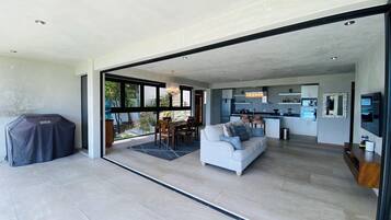 Un espacio habitable moderno con comedor, cocina y un patio cubierto.