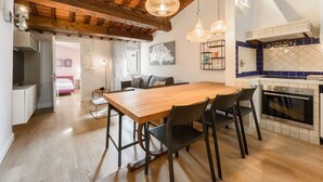 A modern kitchen with wooden cabinets, a built-in oven, and pendant lighting. - Giglio Celeste apartment in Florence by Mmega (Firenze)
