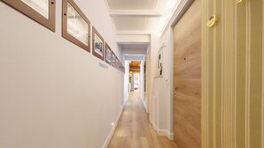 A hallway with framed pictures on the wall, wooden flooring, and a door with a light switch. - Giglio Celeste apartment in Florence by Mmega (Firenze)